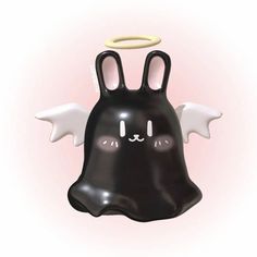 a black plastic toy with white wings and an angel on it's head is in the shape of a ghost