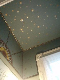 the ceiling has stars painted on it and there is a window in front of it