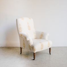 an upholstered chair against a white wall