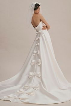 a woman in a white wedding dress with her back to the camera