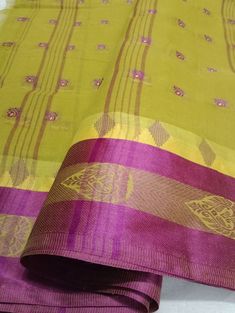 "Introducing our exquisite \"Cotton Confections: Green color with Purple Striped Handloom Saree.\" Handcrafted with love, this cotton saree showcases a delightful pink hue complemented by a charming border design adorned with vibrant green stripes. Experience the perfect blend of comfort and elegance in this lightweight creation, designed to enhance your style for any occasion. Immerse yourself in the timeless allure of this saree, fusing tradition with contemporary flair. Elevate your fashion statement with this captivating masterpiece, now available in green and purple shades." Green Handloom Slub Silk Blouse Piece, Green Slub Silk Handloom Blouse Piece, Green Handloom Pre-draped Saree For Traditional Ceremonies, Green Traditional Wear With Weaving Work For Festivals, Multicolor Slub Silk Saree With Weaving Work, Yellow Handloom Pre-draped Saree In Cotton Silk, Green Chanderi Traditional Wear With Weaving Work, Yellow Handloom Cotton Silk Pre-draped Saree, Yellow Cotton Silk Handloom Pre-draped Saree