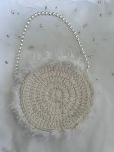 a crocheted white purse with pearls on it