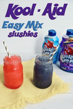 two jars filled with different colored liquids next to each other on a yellow towel and blue bottles