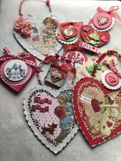 many different heart shaped tags on a white table with pink and red trimmings