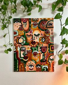 a painting hanging on the wall next to a potted plant with green leaves in it