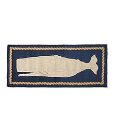 a fish hooked up to a rope on a blue and beige rug with white trim