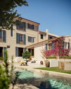 a house with a pool in front of it and flowers growing on the outside wall