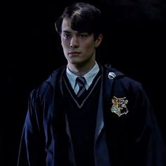 a young man in a harry potter costume is looking at the camera with an intense look on his face