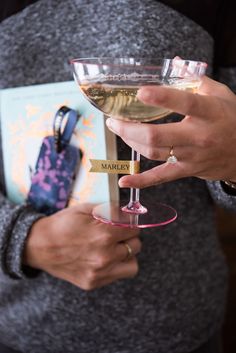 a person holding a wine glass with a book in it