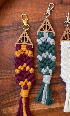 three tassels hanging from hooks on a wooden surface