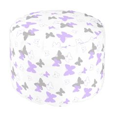 a white and purple bean bag with butterflies on the front, sitting on a white surface