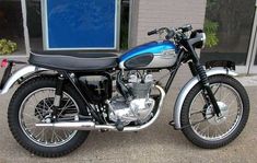 a blue and black motorcycle parked in front of a building