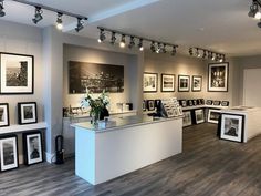 a room filled with pictures and framed photos on the wall next to a counter top