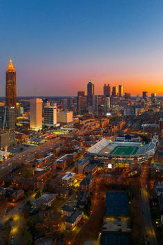 an aerial view of a city at night with the lights on and buildings lit up