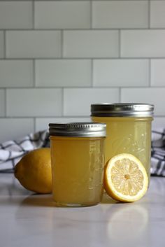 two mason jars filled with lemonade sitting on top of a counter