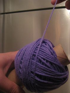 a ball of yarn is being held by someone's hand