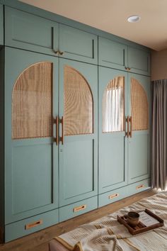 a bed room with a neatly made bed and blue cupboards