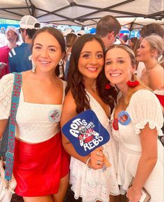 two girls are standing next to each other in front of a tent at an event