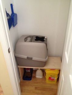 a cat litter box sitting on top of a wooden shelf