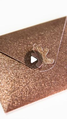 a brown envelope with a hole in the middle and a video play button on it