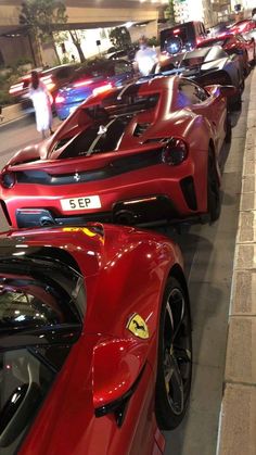 a row of red sports cars parked next to each other