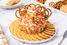 a turkey shaped pretzel sitting on top of a plate next to crackers