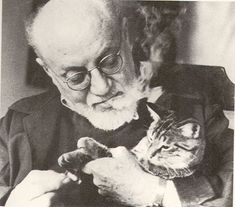 an old man holding a cat in his lap