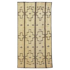 an old rug with geometric designs on the front and back ends, in beige tones