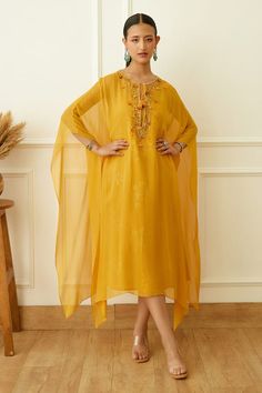 Ochre flared kaftan with sequin embellishments on neckline. Comes with printed inner.
Components: 2
Pattern: Embeoidered,Printed
Type Of Work: Sequin,Floral
Neckline: Keyhole
Sleeve Type: Cape Sleeves
Fabric: Viscose Georgette
Color: Yellow
Other Details: 
Front drawstring detail
Occasion: Sangeet,Cocktail - Aza Fashions Designer Maxi Dress With Embroidered Neckline, Festive Kaftan With Dabka Work For Party, Embroidered Neckline Maxi Dress, Bollywood Style Dresses With Cape Sleeves For Eid, Festive Party Kaftan With Dabka Work, Elegant Diwali Dress With Cape Sleeves, Elegant Dress With Cape Sleeves For Diwali, Elegant Dresses With Cape Sleeves For Diwali, Maxi Dress With Embroidered Neckline