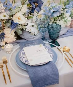 a blue and white table setting with flowers