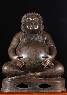 a buddha statue sitting on top of a wooden table