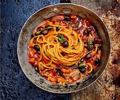 a bowl filled with pasta and vegetables on top of a table