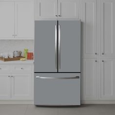 a gray refrigerator freezer sitting inside of a kitchen next to white cabinets and drawers