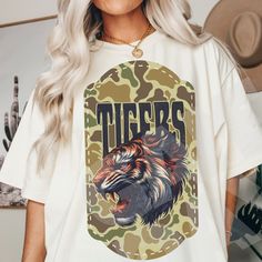 a woman wearing a white tiger t - shirt with the word tigers printed on it