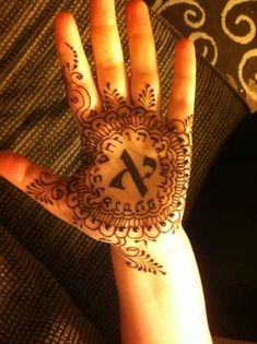 a person's hand with henna on it and the letter k painted on it