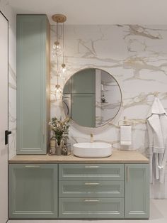 a bathroom with green cabinets and a round mirror