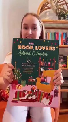 a girl is holding up a book that says the book lover's advent calendar