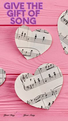 three paper hearts with musical notes on them and the words give the gift of song