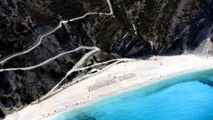 an aerial view of a beach with blue water