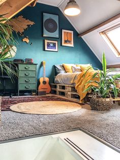 a bedroom with blue walls and green furniture in the corner is decorated with potted plants