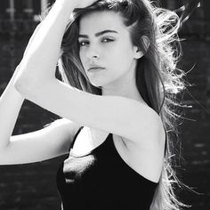 black and white photograph of a woman with her hair blowing in the wind, wearing a halter top