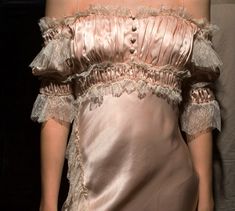 a woman wearing a dress with ruffles on it