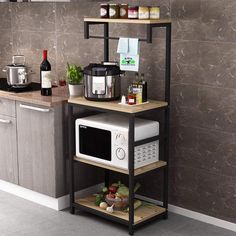 a microwave oven sitting on top of a wooden shelf next to a counter with spices and condiments