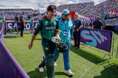 two cricket players walking on the field