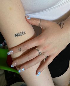 two girls with matching tattoos on their arms and one has the word angel tattooed on her arm