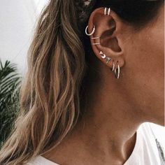 a woman wearing ear piercings with the word love on it