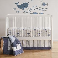 a baby's room with a white crib and blue wall decals