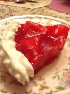 a piece of cake on a plate with whipped cream and strawberries in the middle