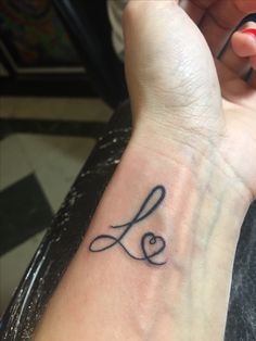 a woman's wrist with a tattoo that says love on the left side of her arm