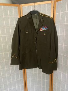 Vintage army green military jacket. Missing the bottom most button. The gold ropes on the sleeves/shoulders and the gold studded details on the collar have been hot glued on and are not part of the original coat. There is one hot glue spot on the left elbow but in great shape otherwise. Labeled size 37R Military Style Blazer With Button Closure, Military Style Double-breasted Blazer, White Nightgown, Military Jacket Green, Matching Robes, Hot Glue, Label Sizes, Shoulder Sleeve, Army Green